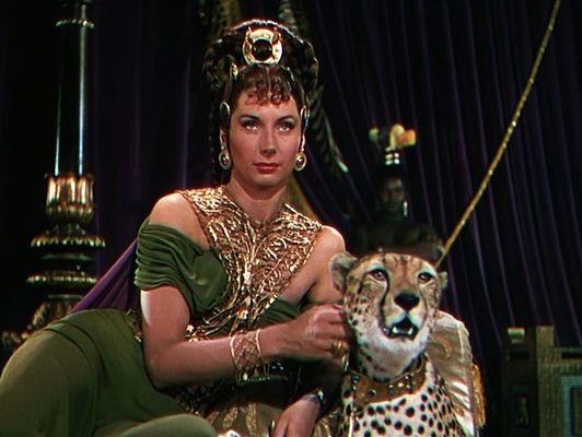 Patricia Laffan as Poppaea Sabina. She wear a rich green and gold gown, as well as an elaborate headdress. She also has a cheetah on a leash.