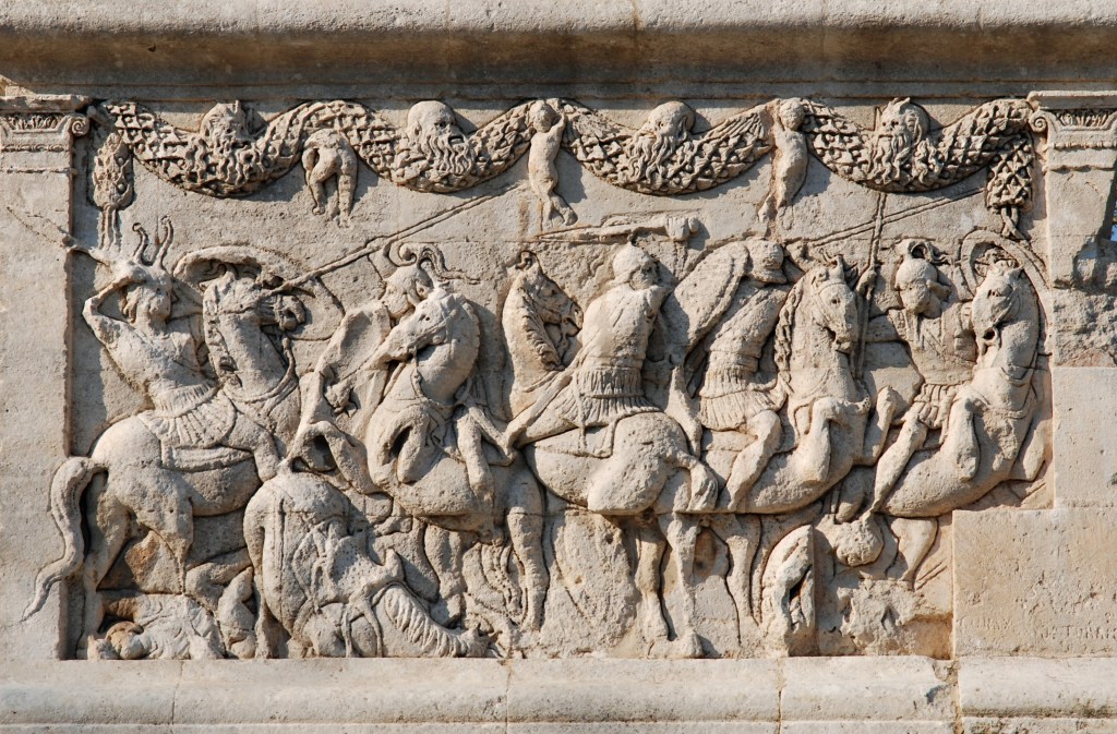 A relief depicting a cavalry battle from c. 40 BCE. Horses are in action with the bodies of enemies on the ground. Garlands decorate the upper register.