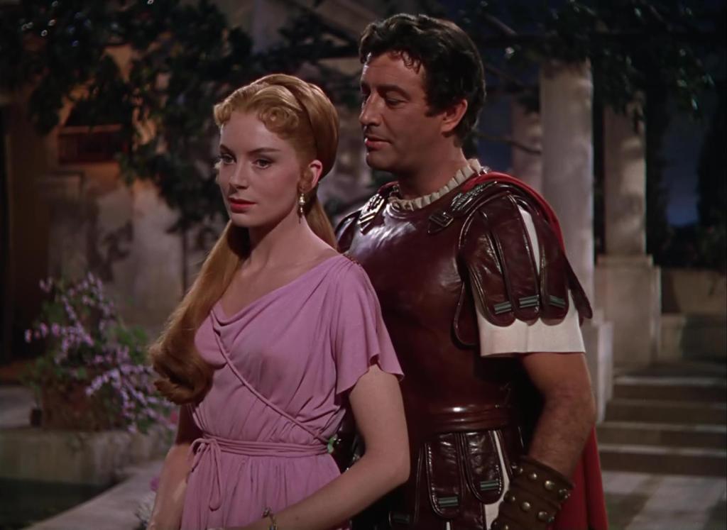 Deborah Kerr and Robert Taylor in Quo Vadis. He stands behind her seemingly bewitched by her beauty.